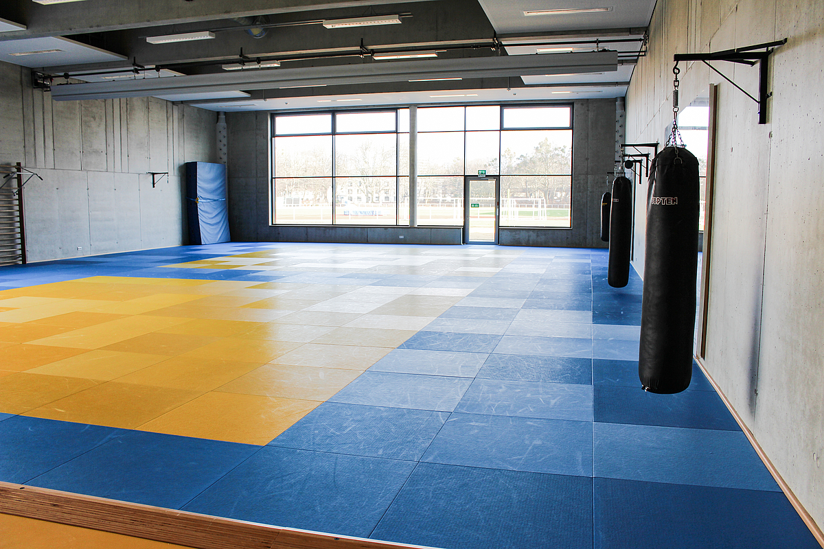 Innenansicht der Budohalle mit Matten und Boxsäcken.