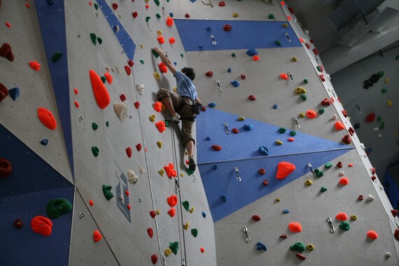 Kletterwand mit Kletterer.