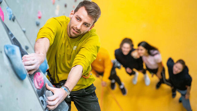 Kletterin und Sichernder an der Kletterwand.