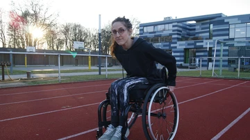 Eine Sportlerin im Rollstuhl auf einer Tartanbahn.