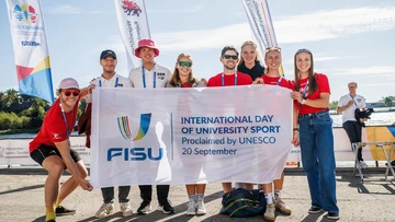 8 Ruder*innen halten die FISU International Day of University Flagge hoch