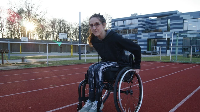 Eine Sportlerin im Rollstuhl auf einer Tartanbahn.